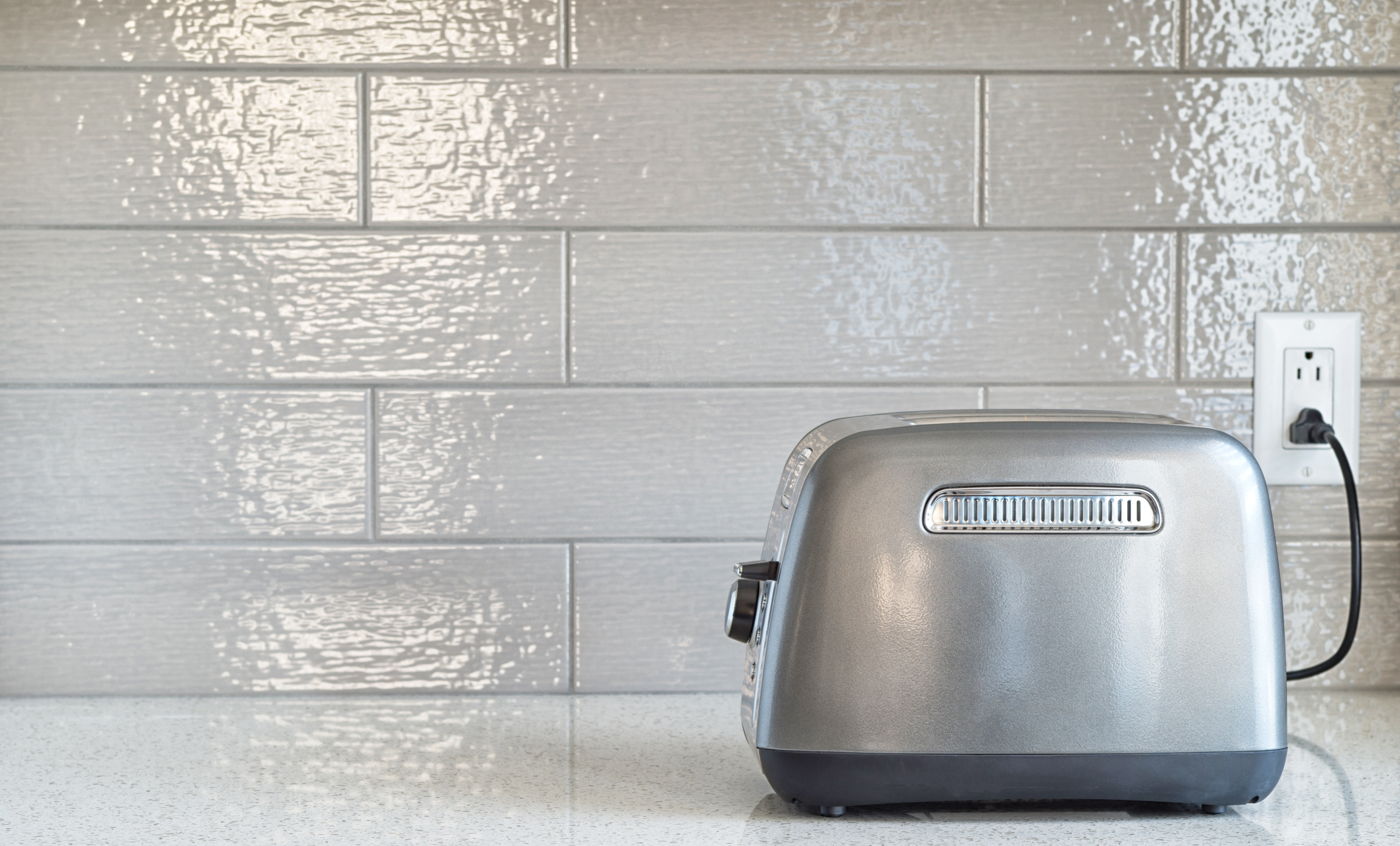 Toaster plugged into safe kitchen electrical points near breakfast counter