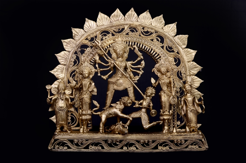 Traditional Bengali home decor with brass Durga idol and intricate detailing