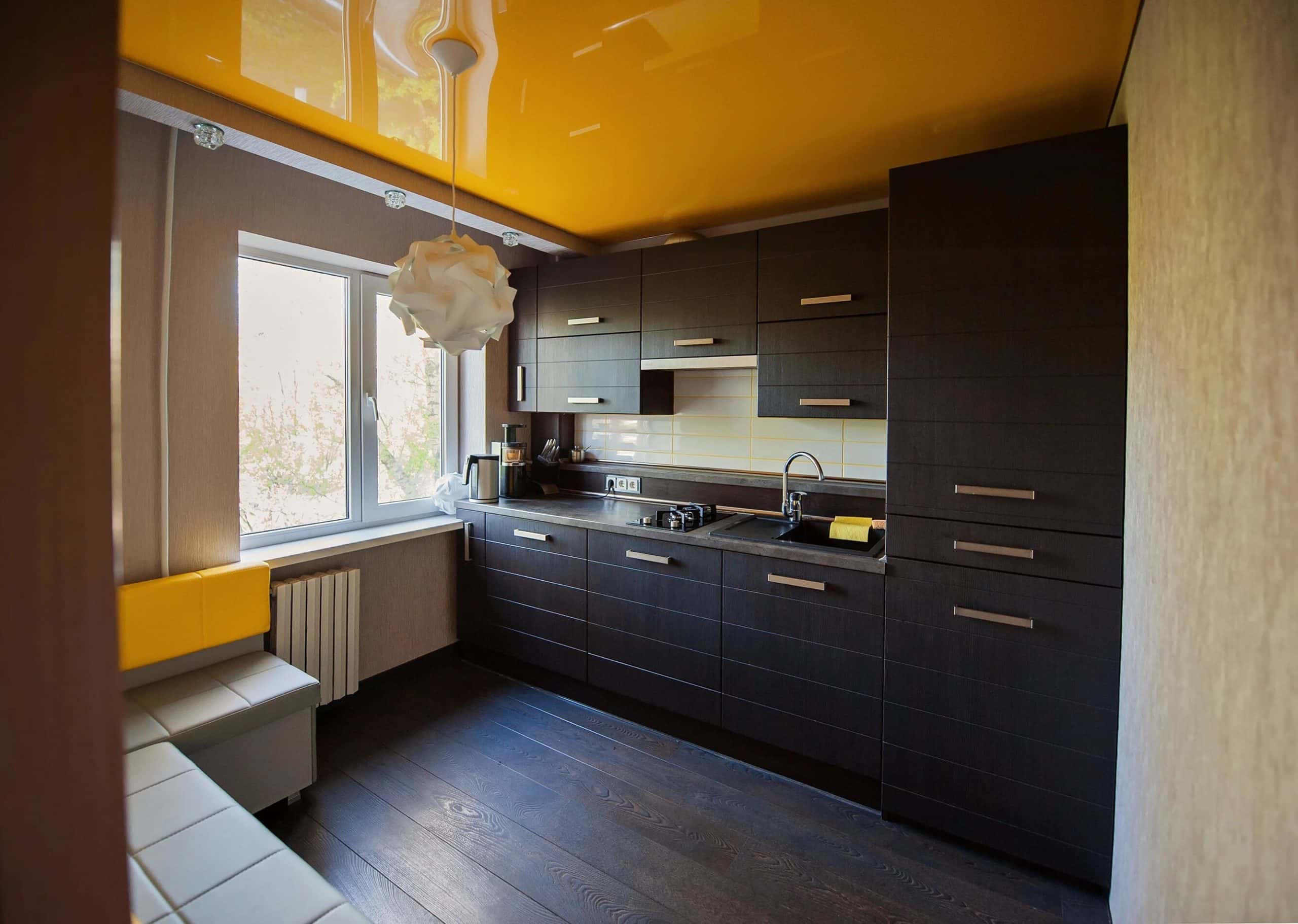 Black and orange modular kitchen design colour with contrasting ceiling highlights