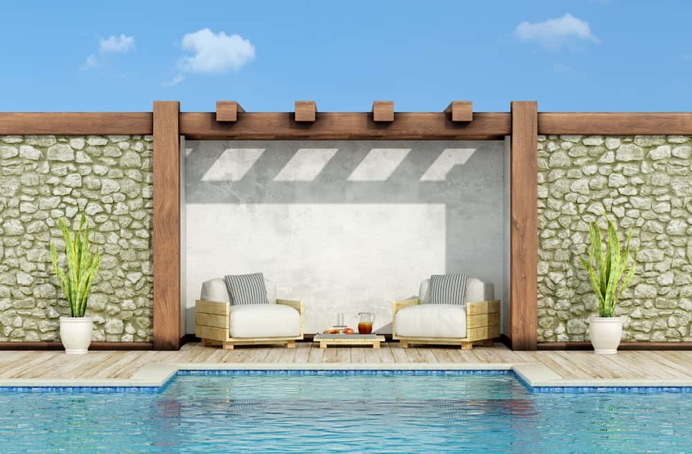 Poolside Stone Boundary Wall Design with wooden frame panels