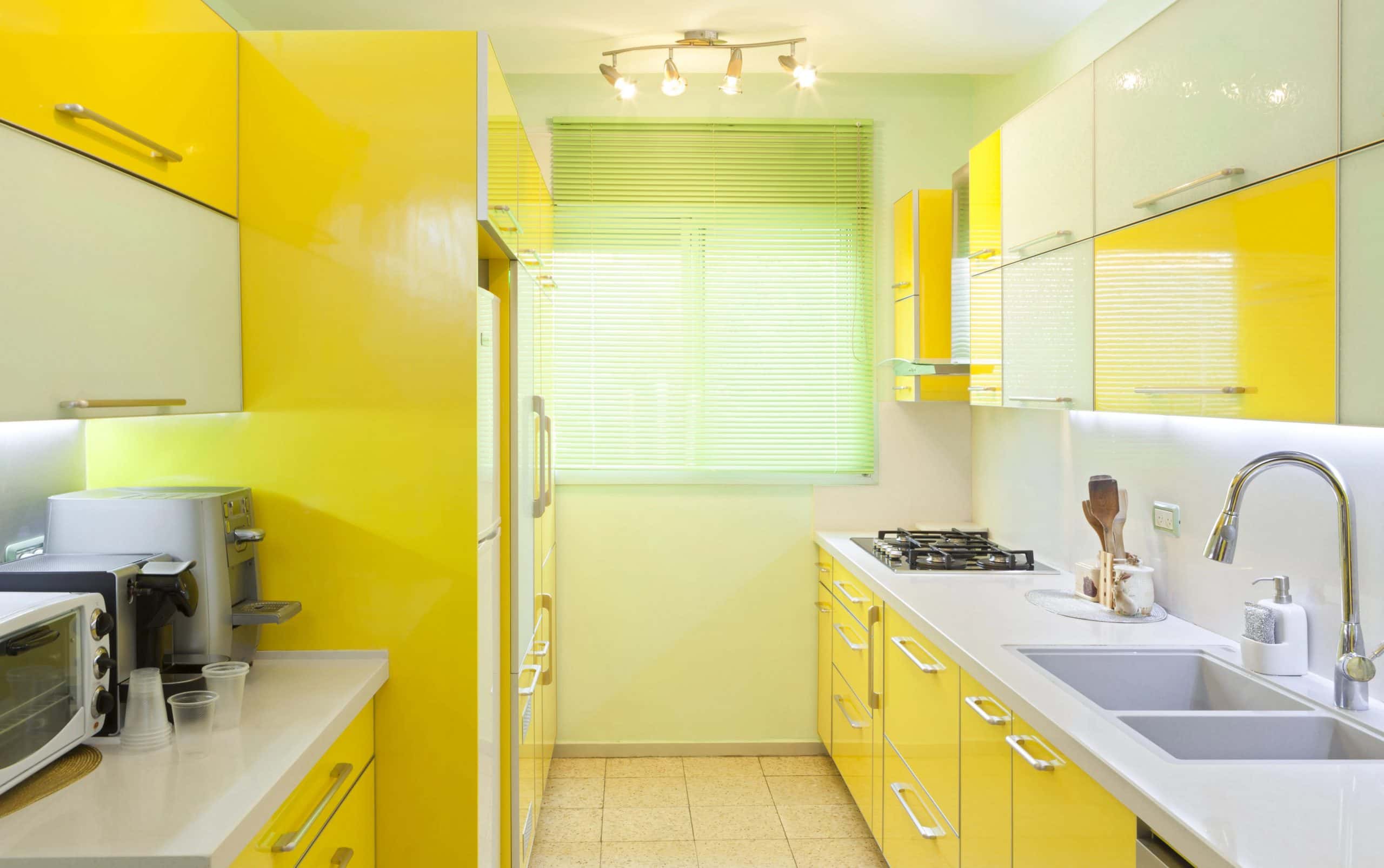 Small modular kitchen in yellow and white colour combination for vibrant ambience