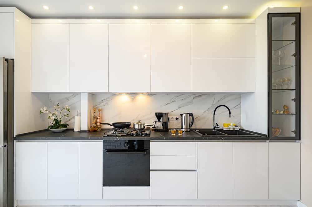 Modern parallel kitchens designs with white cabinets and black countertop
