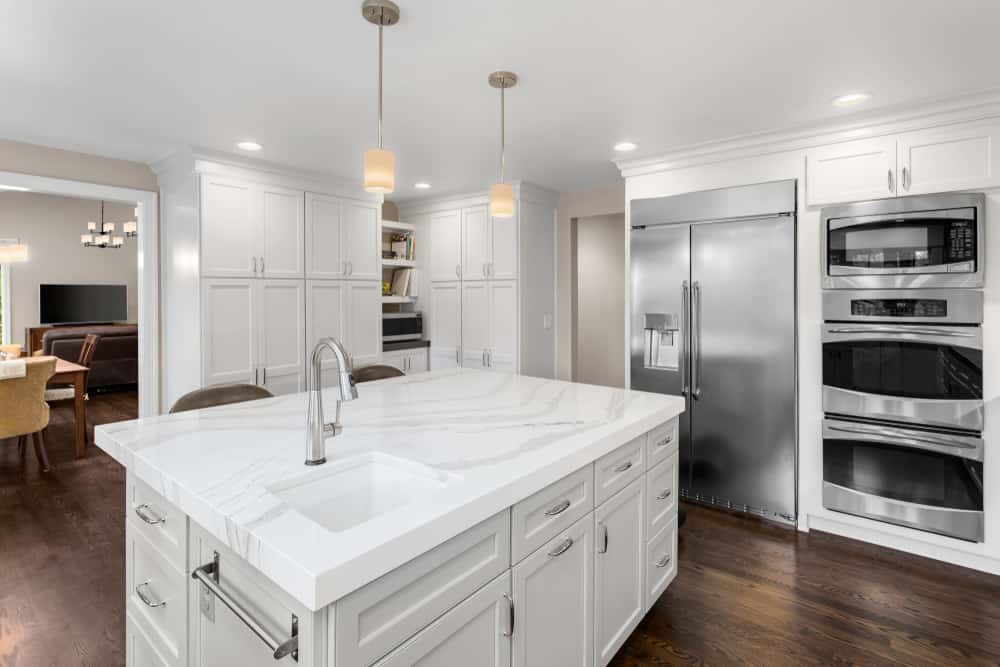 White kitchen island designs with marble countertop and sink