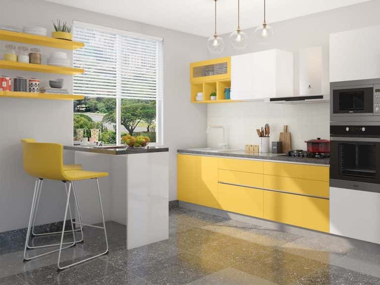 Bright industrial kitchen with yellow and white cabinets and a cozy breakfast counter
