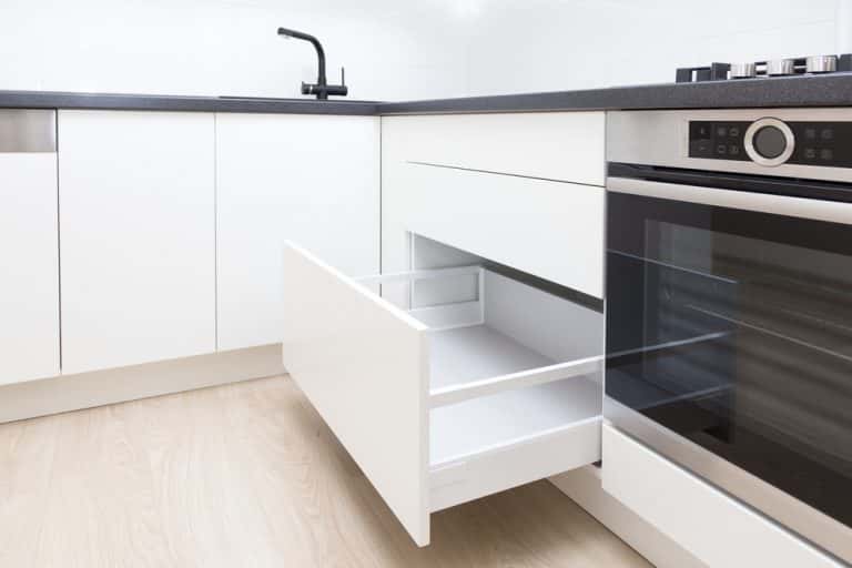 White handleless modular kitchen with sleek cabinet drawer design 