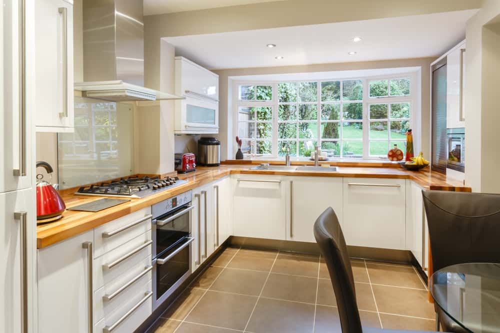 L-shaped modular kitchen designs with large glass window setup