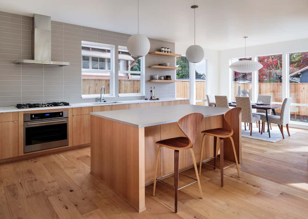 Spacious mid-century modern kitchen designs with wood island and pendant lights