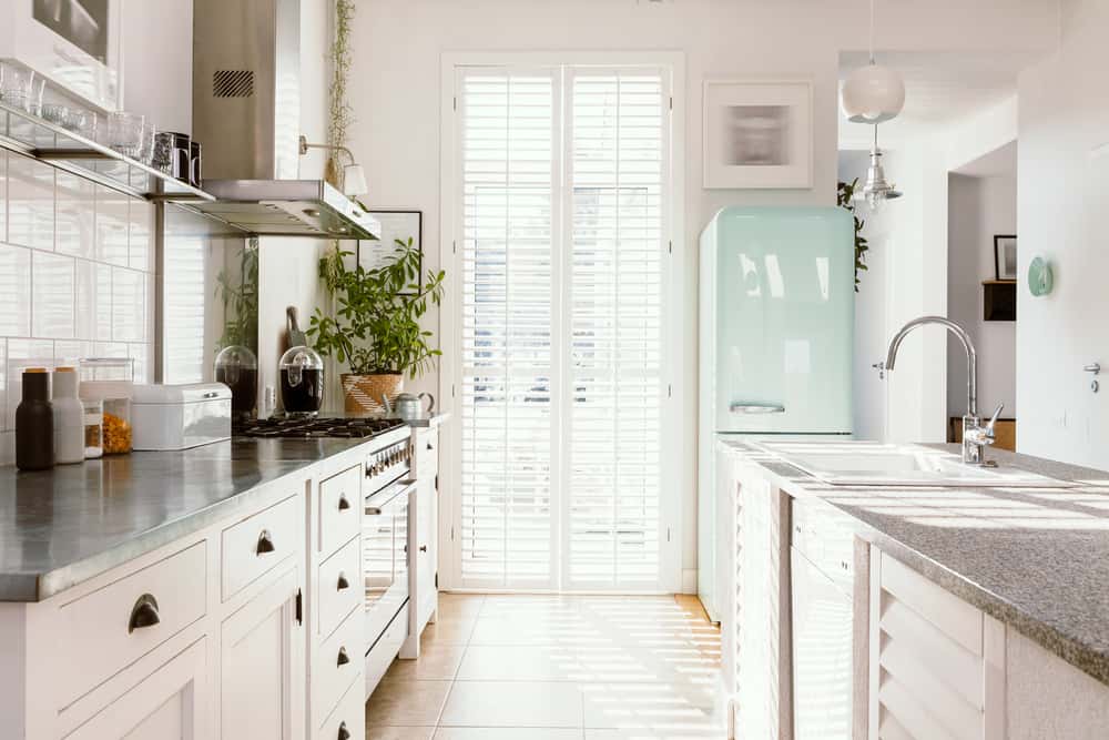 Bright mid-century modern kitchen designs with pastel fridge and white cabinets