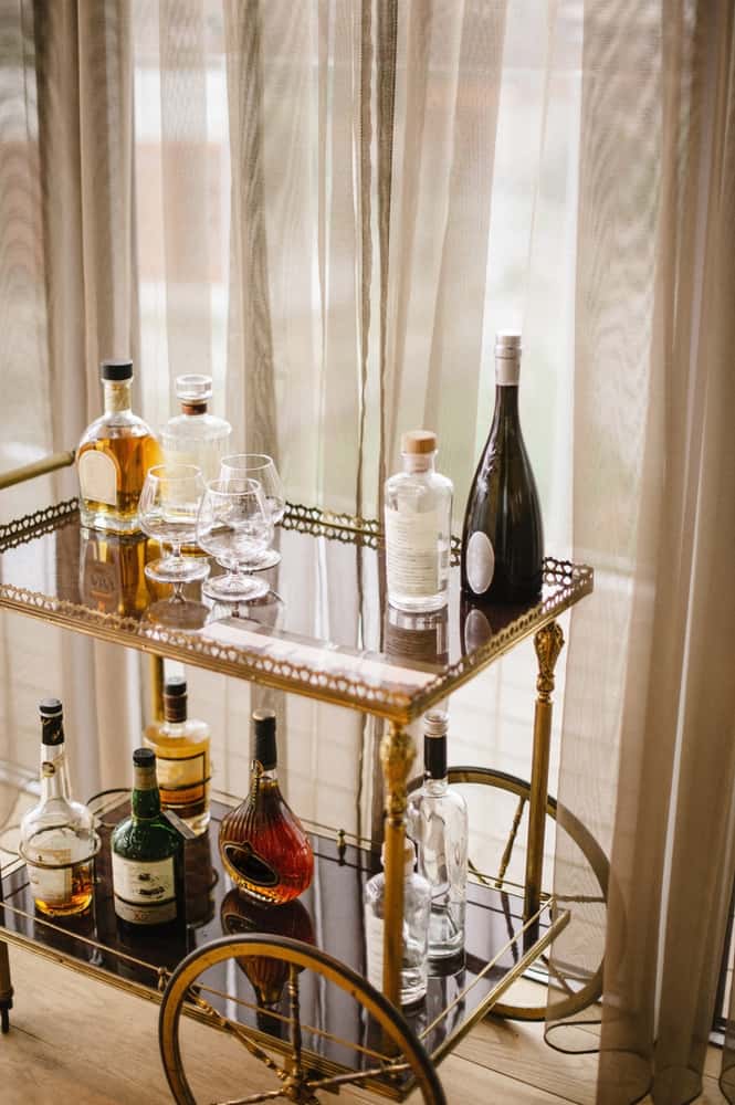 Stylish mid century modern kitchen remodel idea with vintage gold bar cart