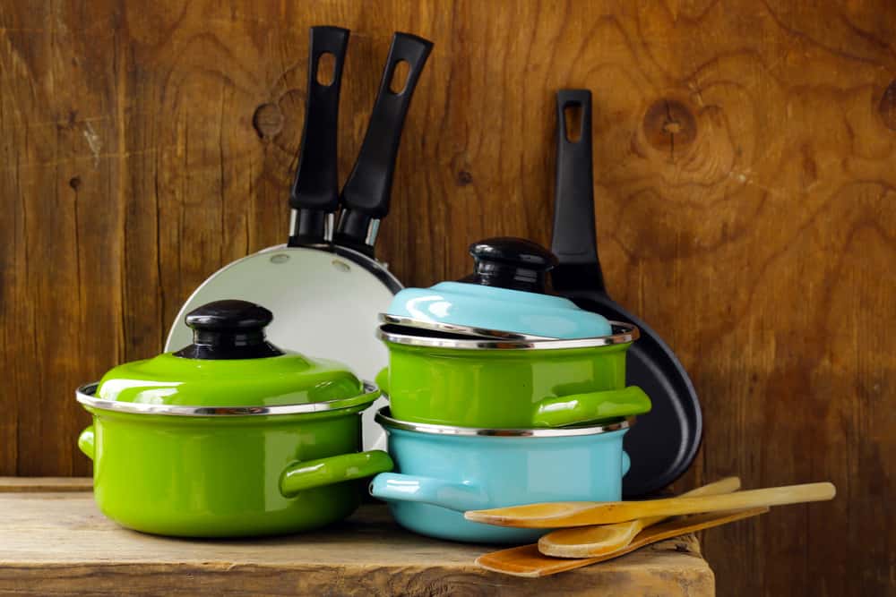 Colorful mid century modern kitchen set with enamel pots and wooden spoons