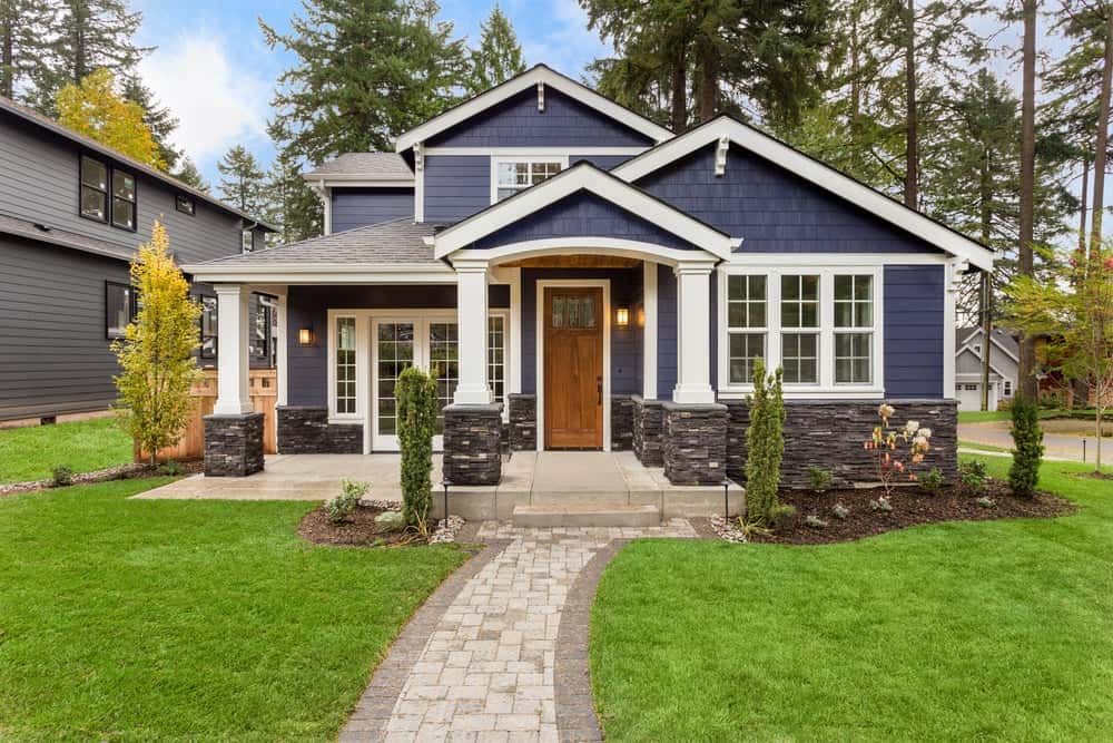 Chic front elevation colour combinations with navy blue siding, white trim, and stone accents