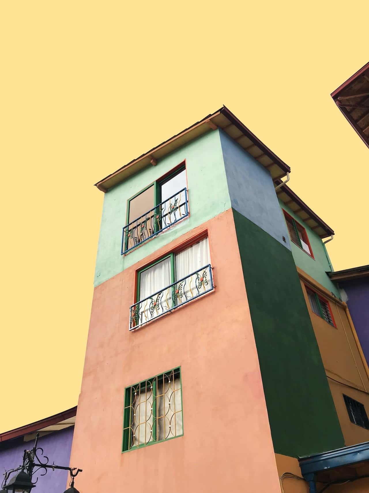 Bold front elevation colour combinations with pastel green, peach and deep bottle green tones