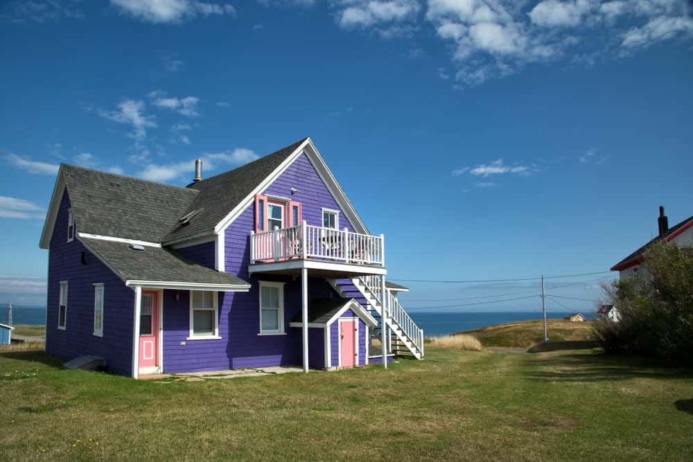 Playful front elevation colour combinations with purple, pink, and white coastal house tones