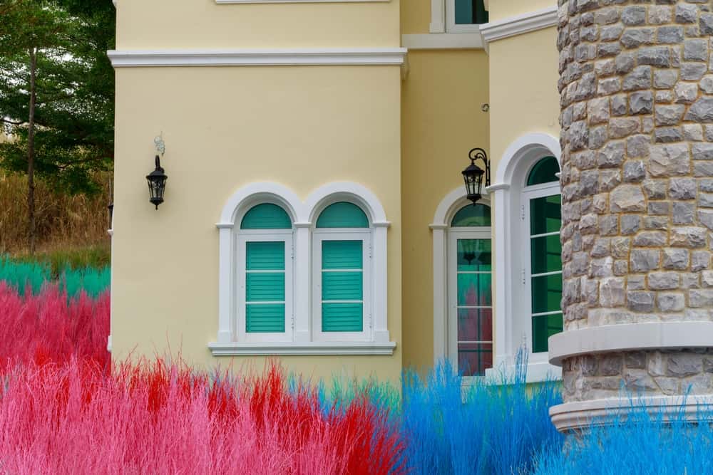 Vibrant front elevation colour combinations with pastel yellow walls and teal windows