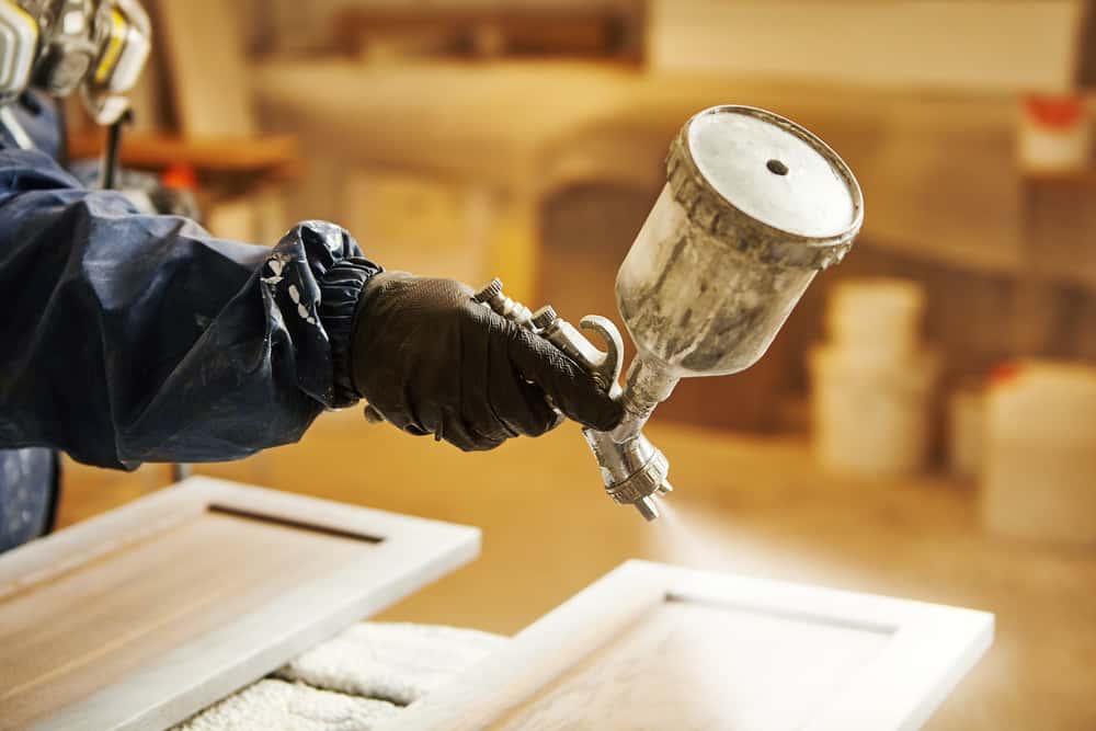 Spray application during duco vs pu paint process on a kitchen cabinet door