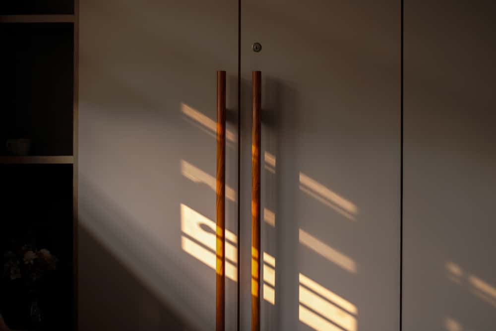 Sunlight falling on sleek wardrobe handle in a matte-finish cabinet
