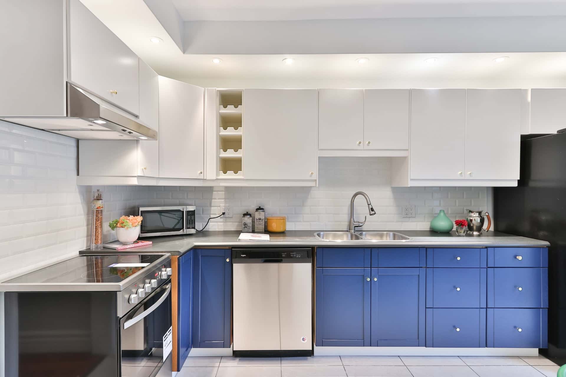 Contemporary cafe style kitchens with blue lower cabinets and bright white tiling