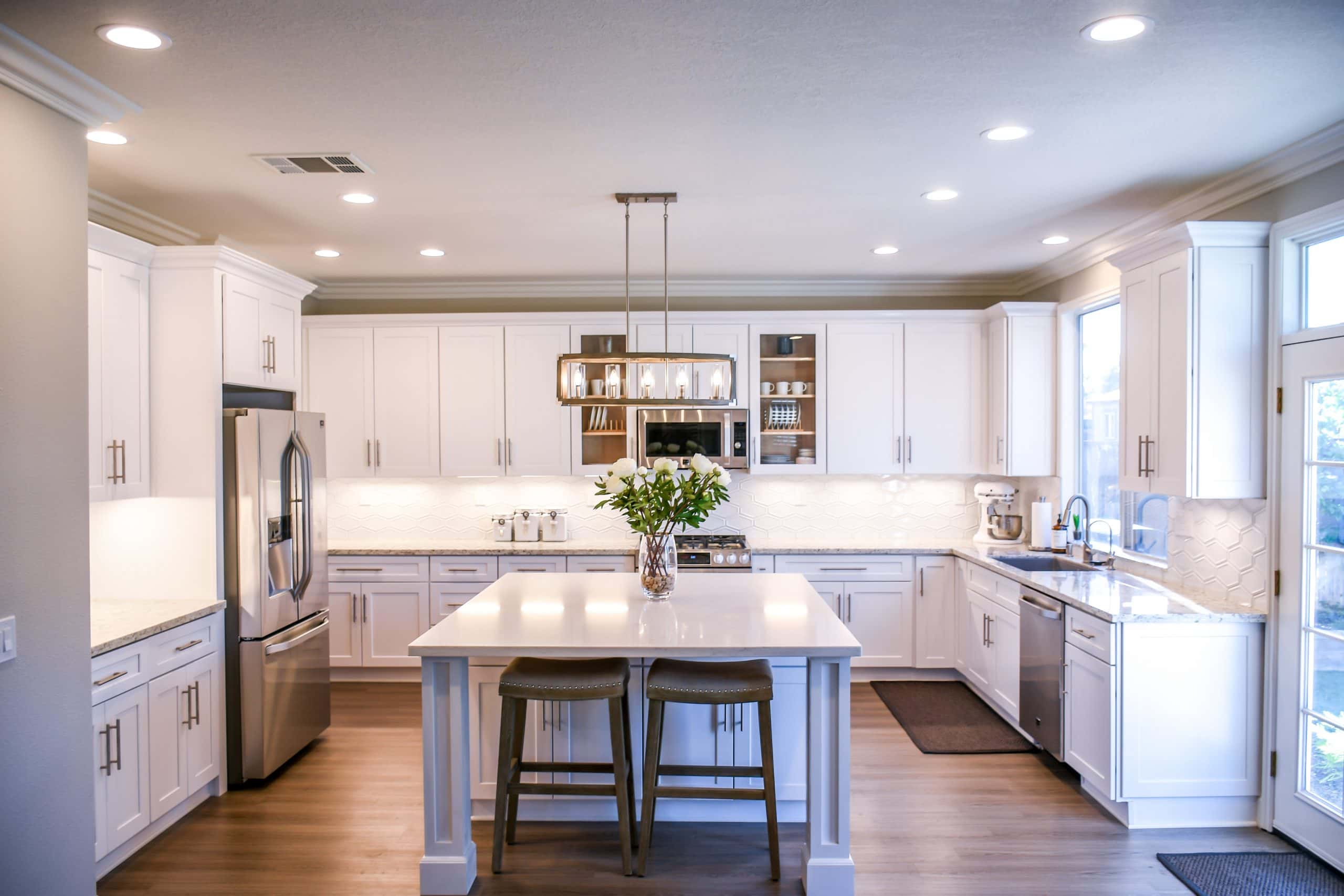 Luxury cafe style kitchens with bright white cabinets and center island lighting
