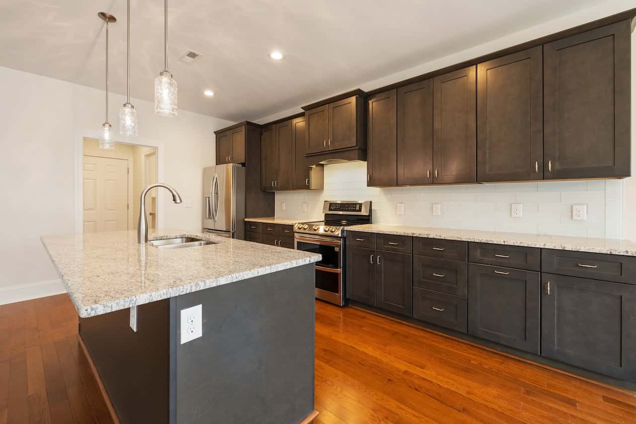 Sleek kitchen cupboard door designs with dark cabinets and granite countertops