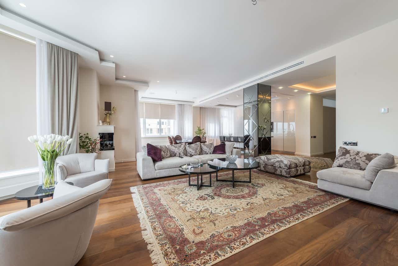 Elegant lobby interior design with cozy seating, mirrored wall, and rich wooden flooring