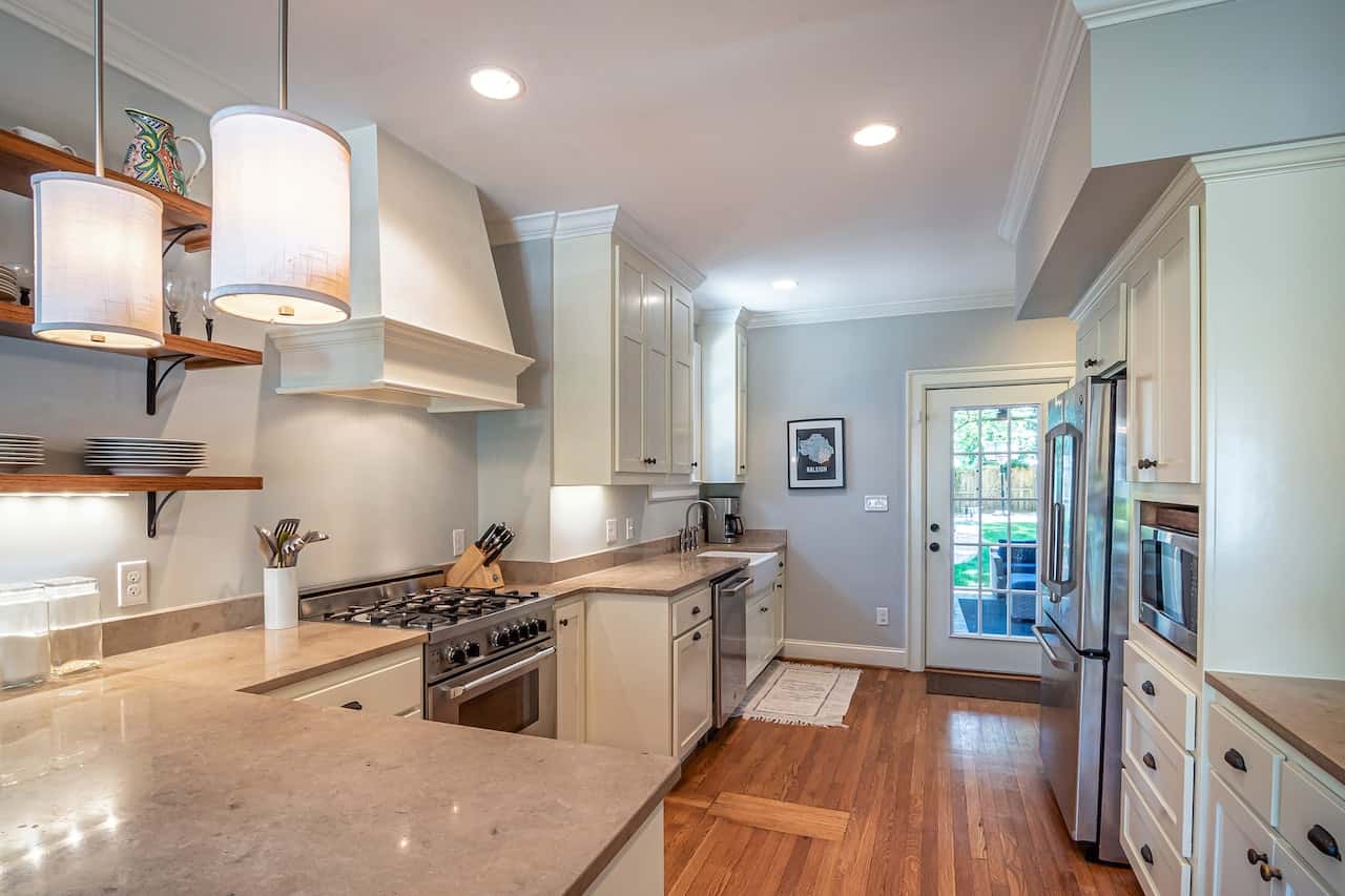 Cozy kitchen cupboard door designs with warm wood floors and elegant white cabinets