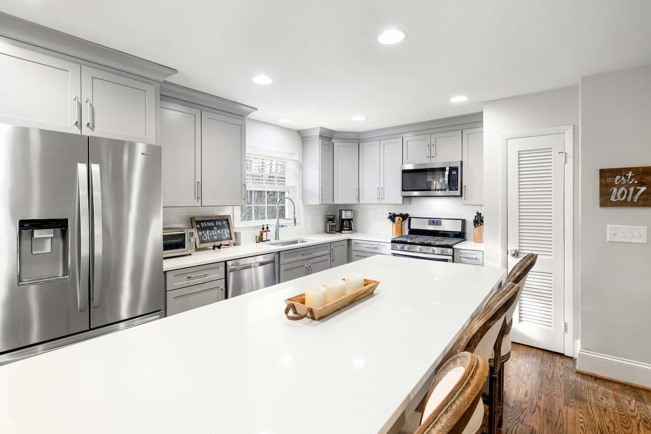 Bright kitchen cupboard door designs with grey cabinets and wood-finish flooring