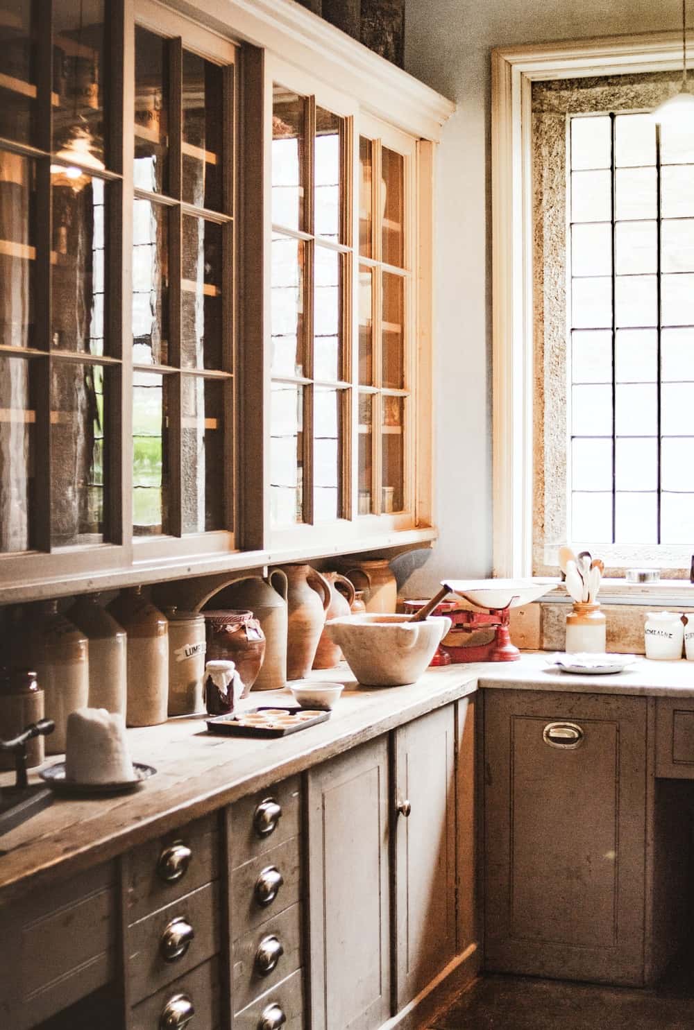 Vintage cafe style kitchens with antique jars and natural light through paned windows