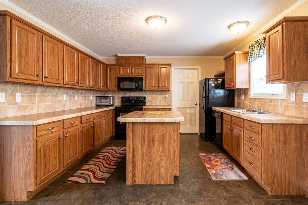 Traditional kitchen cupboard door designs with wood finish and classic Indian layout