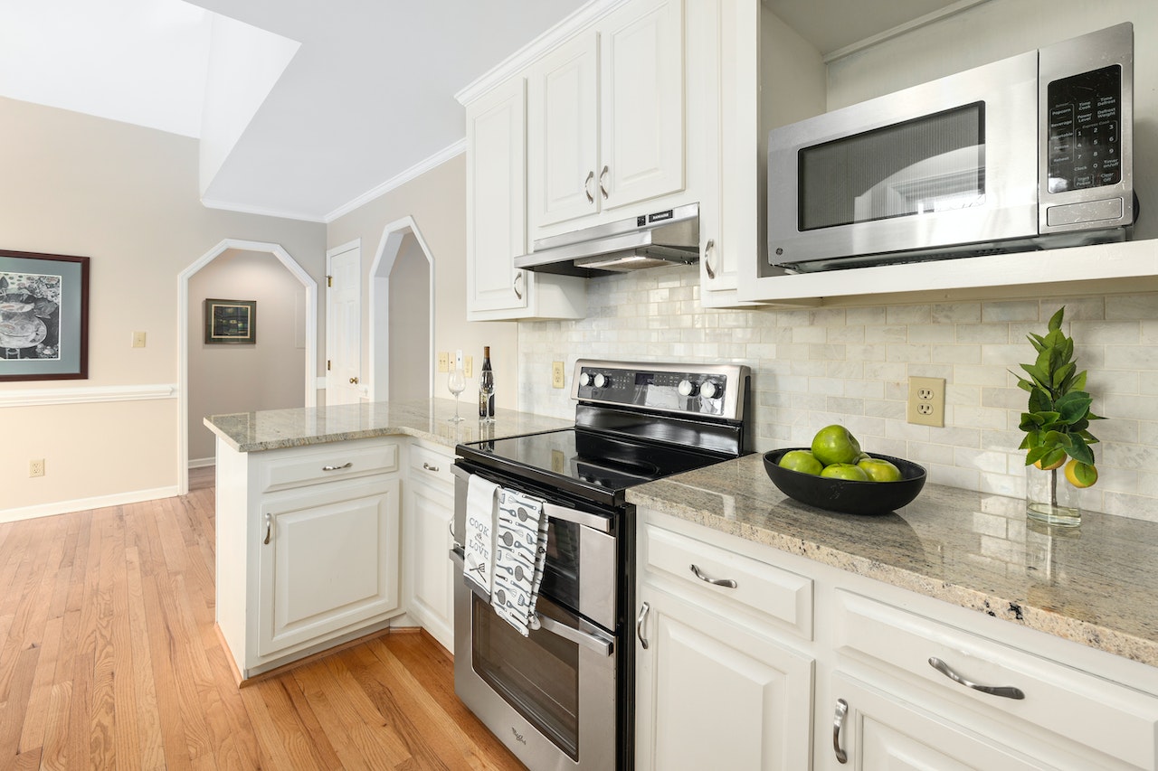 Kitchen entrance design with white cabinets and wood floors. 