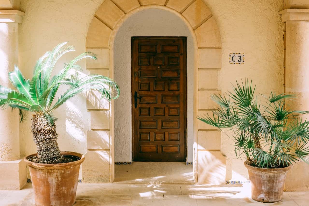 Mediterranean touch pop design for porch with arch pillars and classic wood door