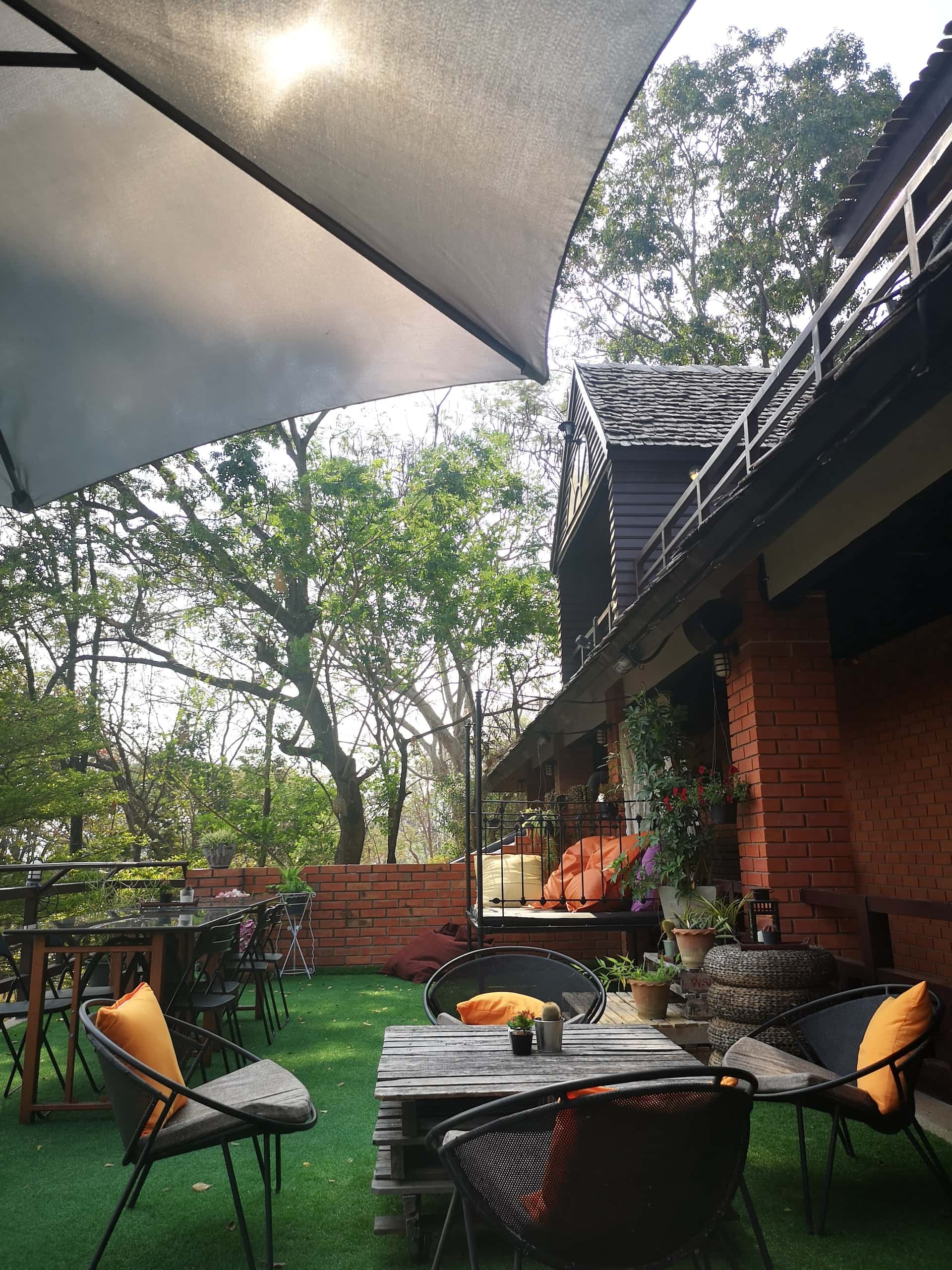 Inviting sitout design with outdoor seating, green turf, and shade umbrella