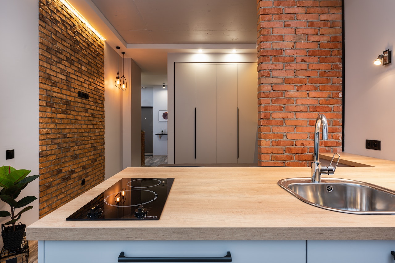 Minimalist kitchen entrance design with exposed brick and modern sink