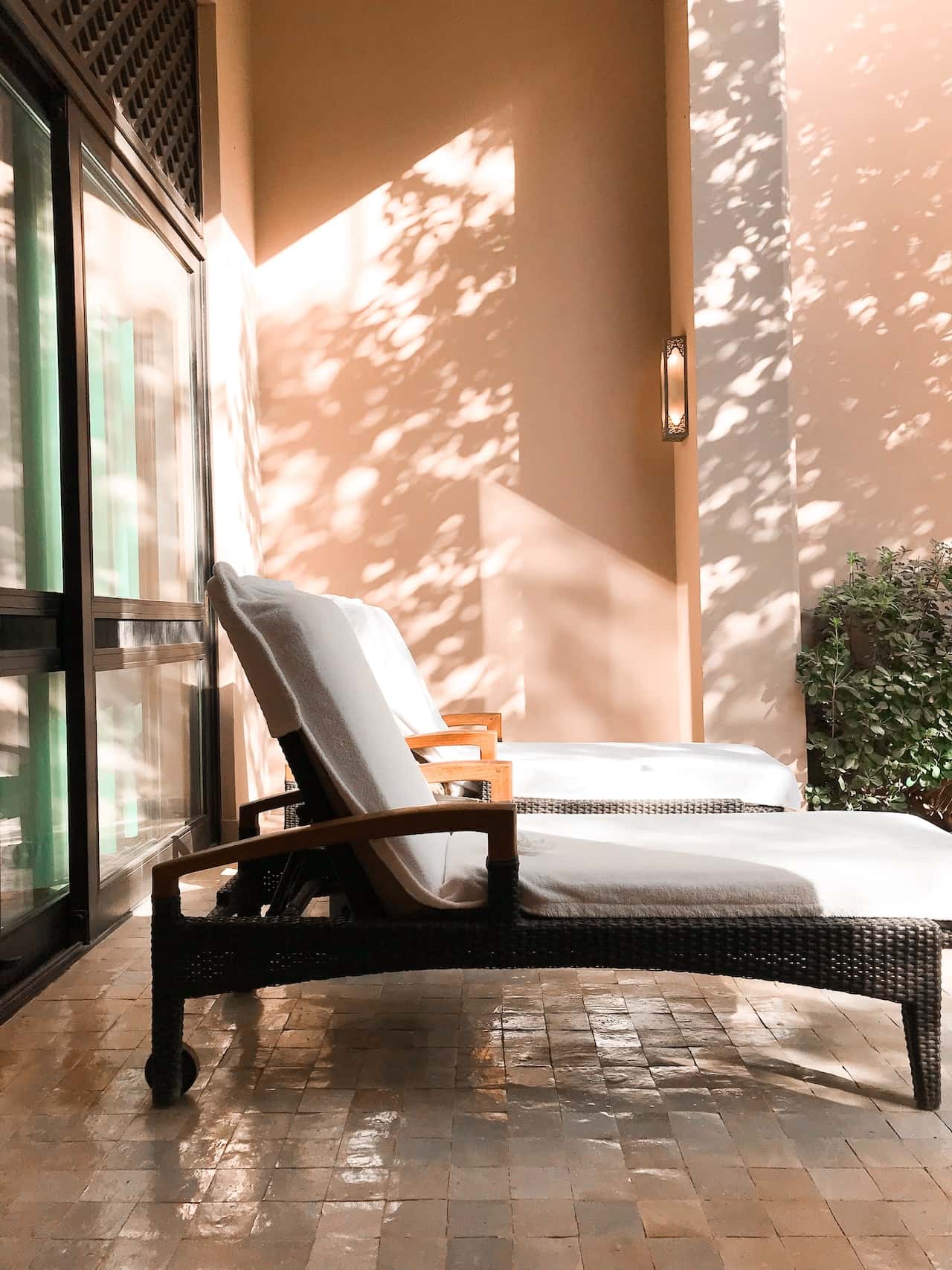 Elegant sitout design with wicker loungers and soft cushions in sunlit patio