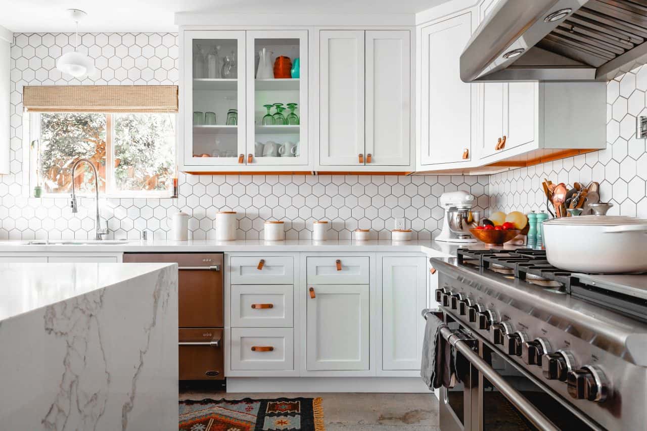 Bright standard kitchen size with hex tile backsplash and white cabinets