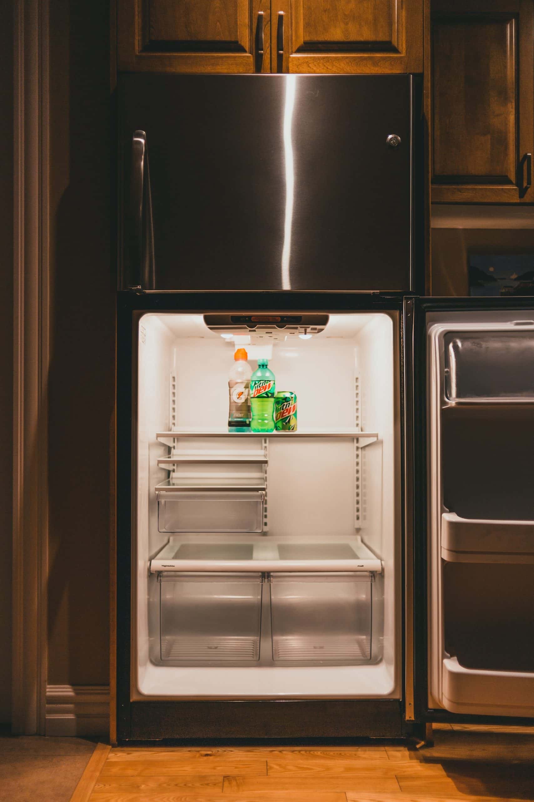 Built-in standard kitchen size fridge with open door and drinks inside