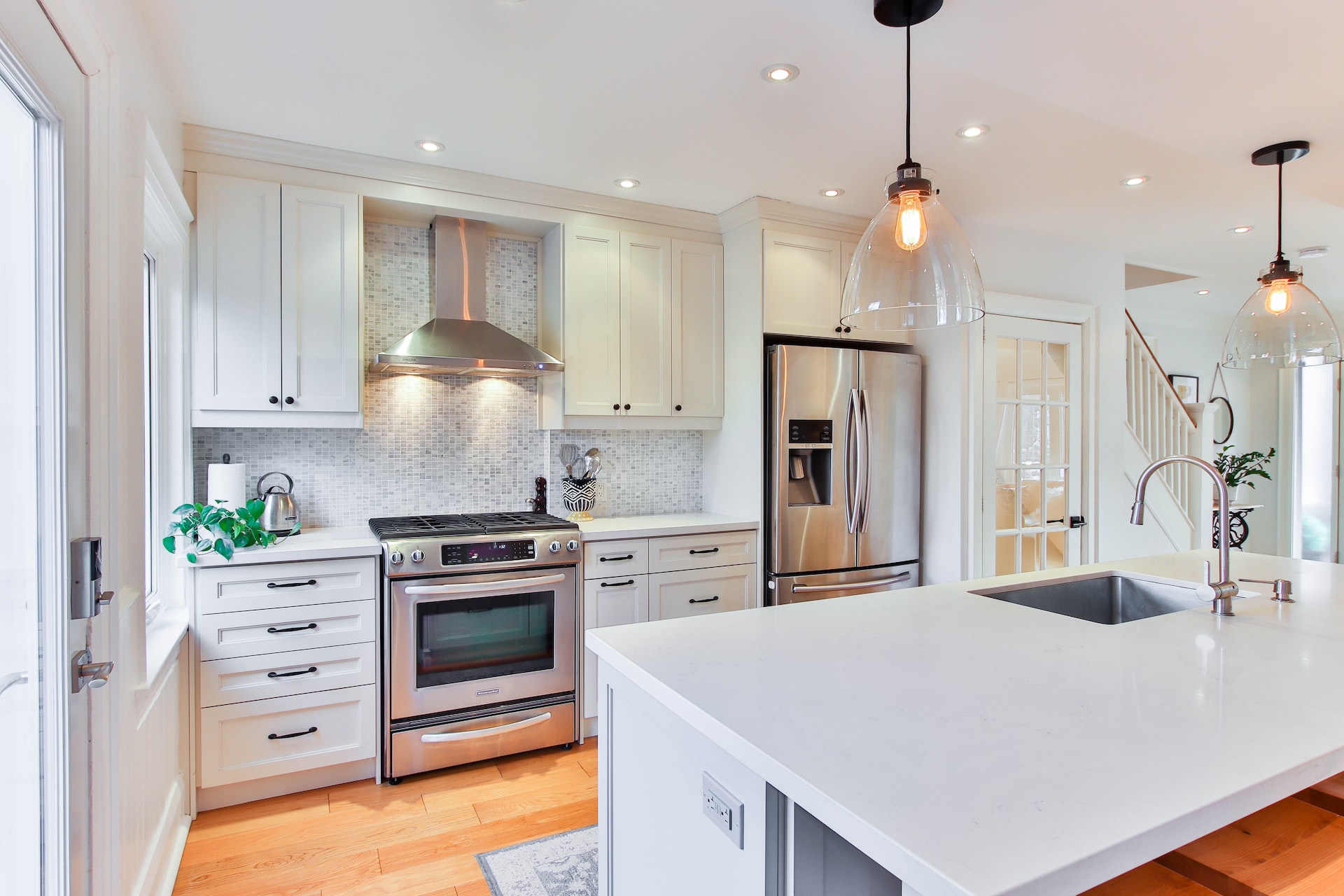 Bright kitchen entrance design with white cabinets and pendant lights