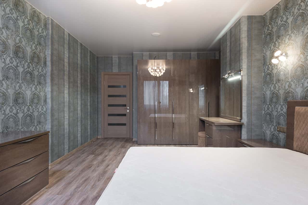Elegant bedroom flush door designs with wooden wardrobe and modern wallpaper