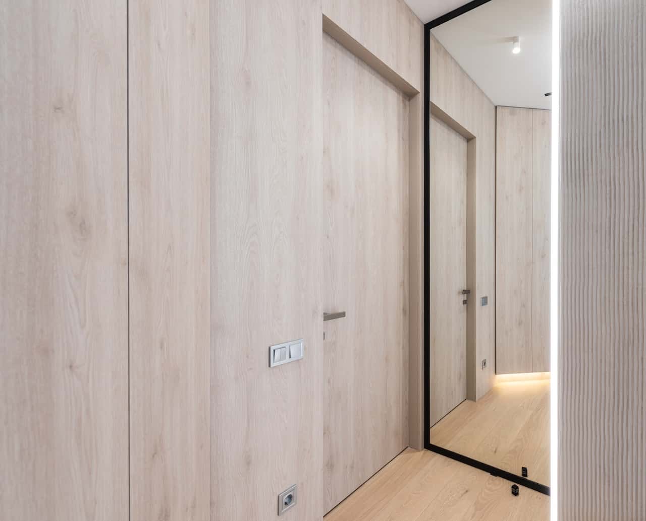 Elegant flush door designs with light wood finish in a modern hallway