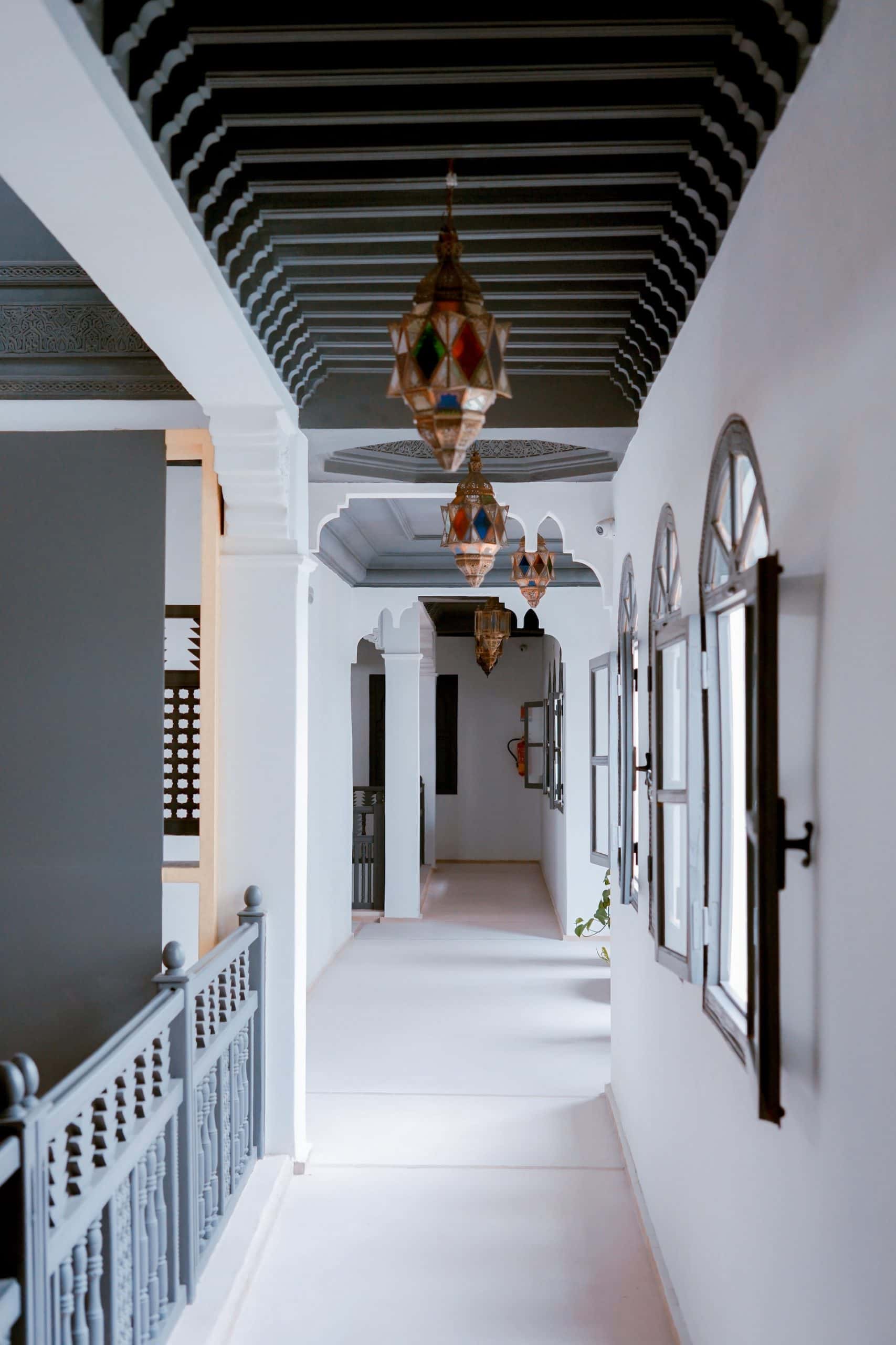 Elegant pop design for porch featuring ornate beam ceiling and vintage lanterns