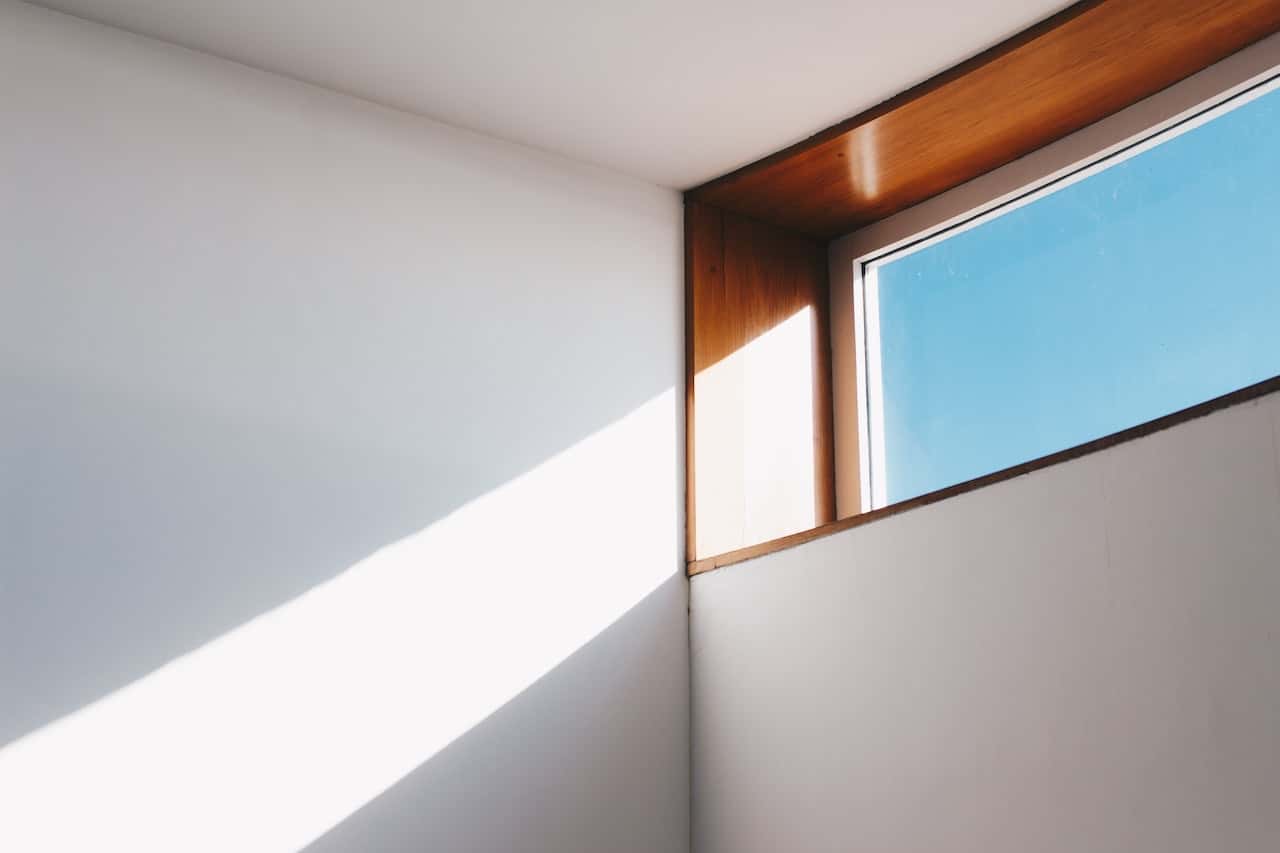 Natural light enters through ceiling window design in minimalist wood-accented space