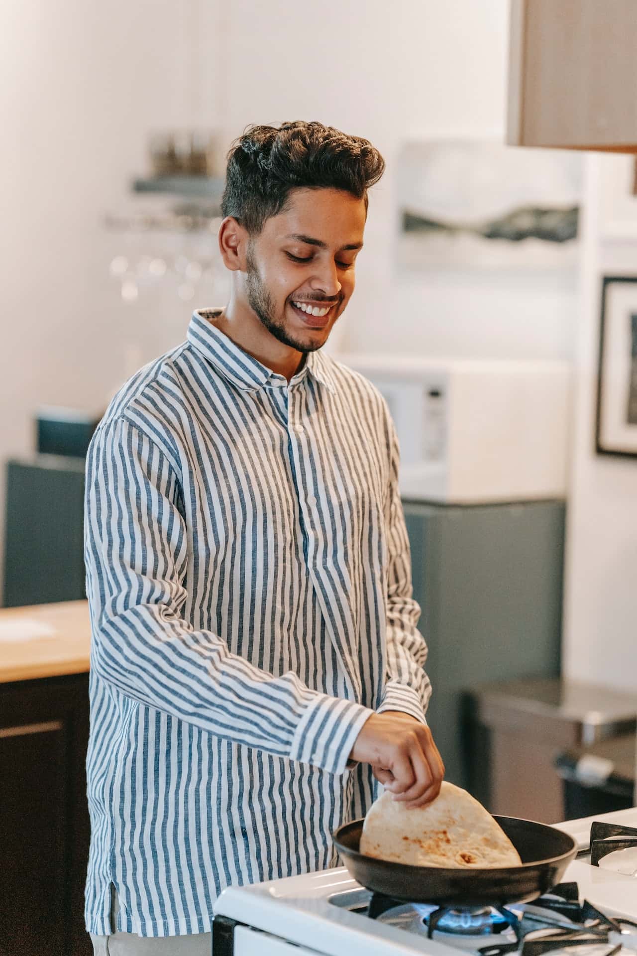 Man in standard kitchen size cooking joyfully in a cozy and modern layout