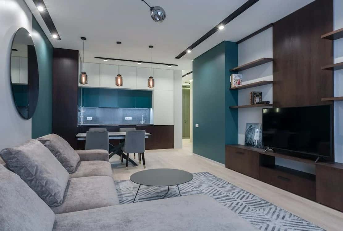 Stylish open living room with teal accents and sleek modern entertainment unit