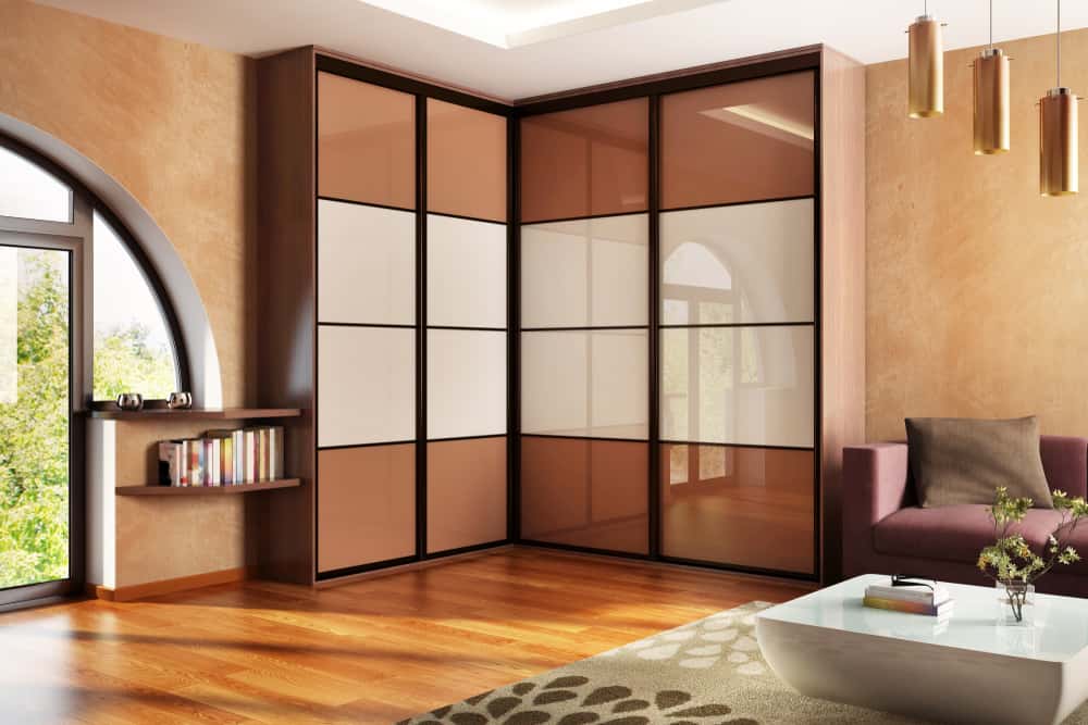 Contemporary corner wardrobe with sliding glass doors in a warm-toned living space