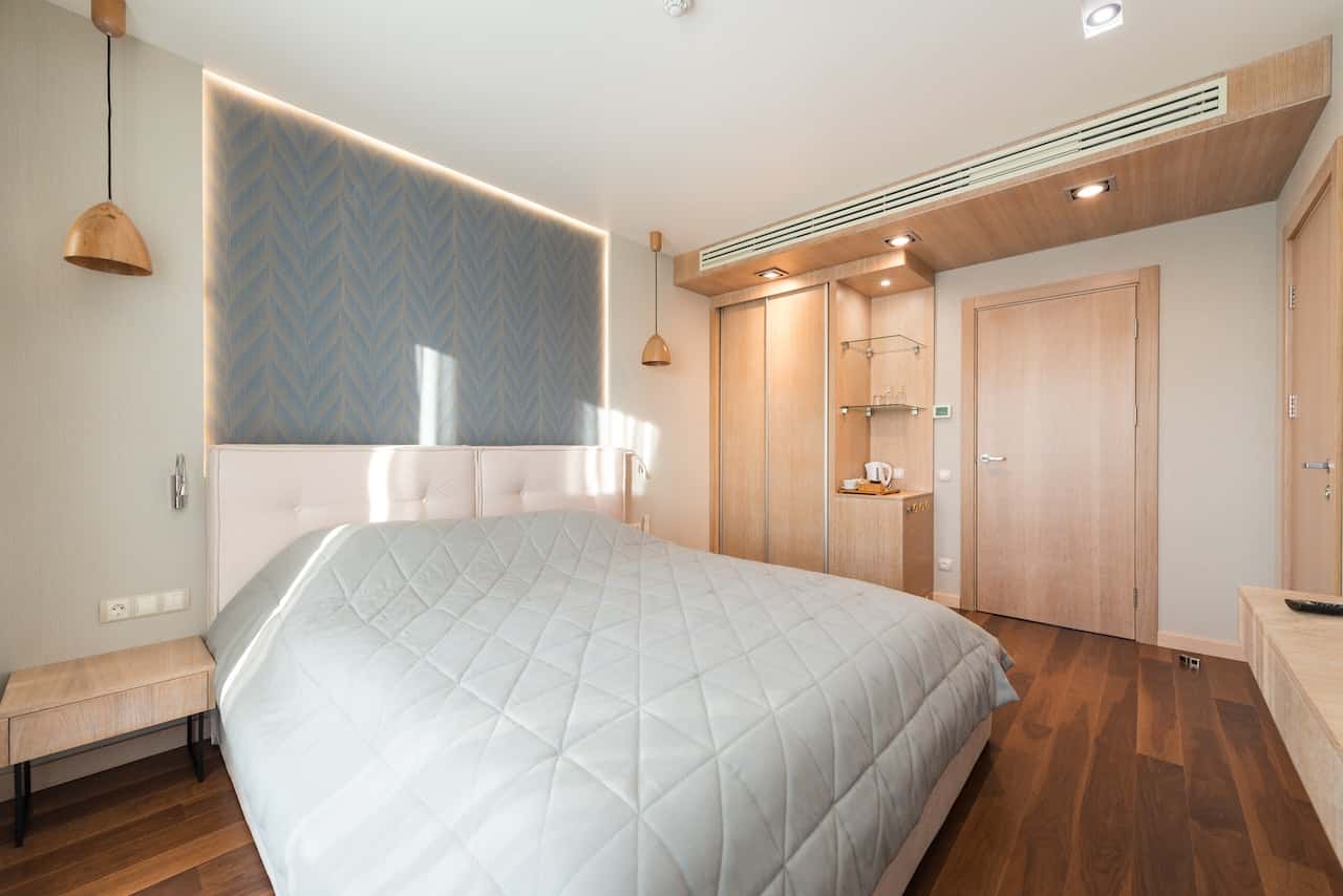 Cozy bedroom flush door designs in light wood with wardrobe and soft lighting