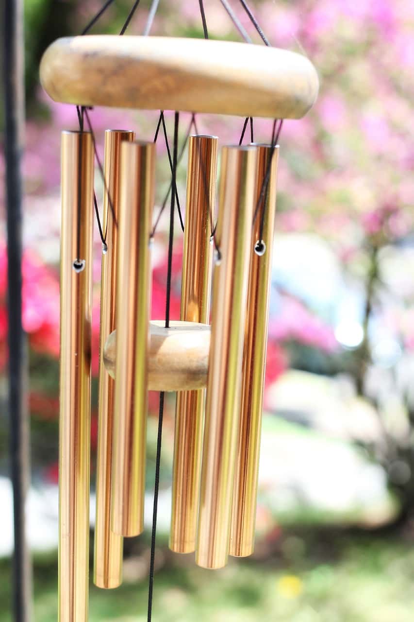 Golden metal wind chimes vastu element glowing outdoors to attract positive energy