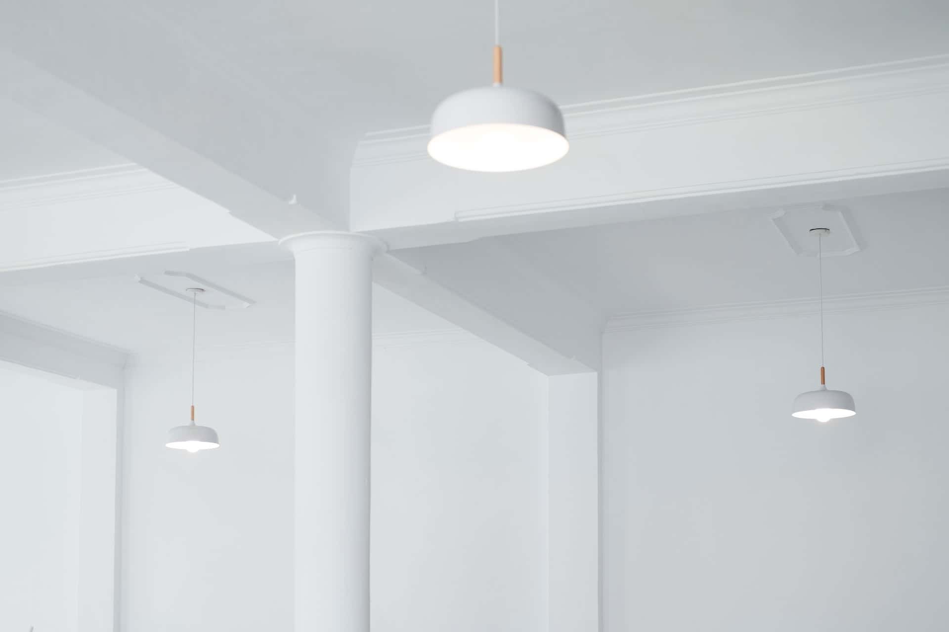 Minimal false ceiling design with suspended modern lights in a white interior