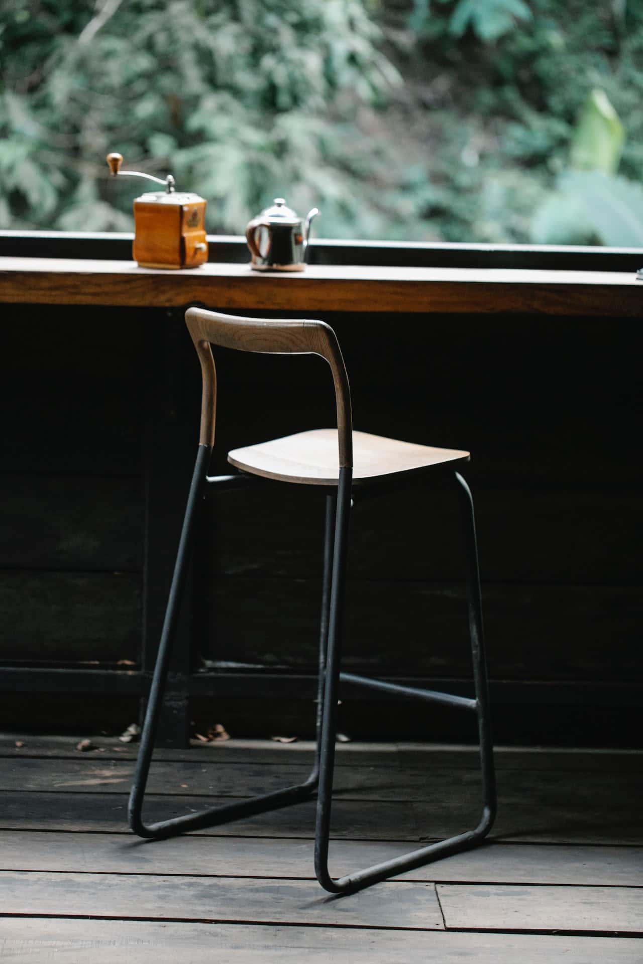 Minimalist sitout design with high wooden chair and coffee setup by window