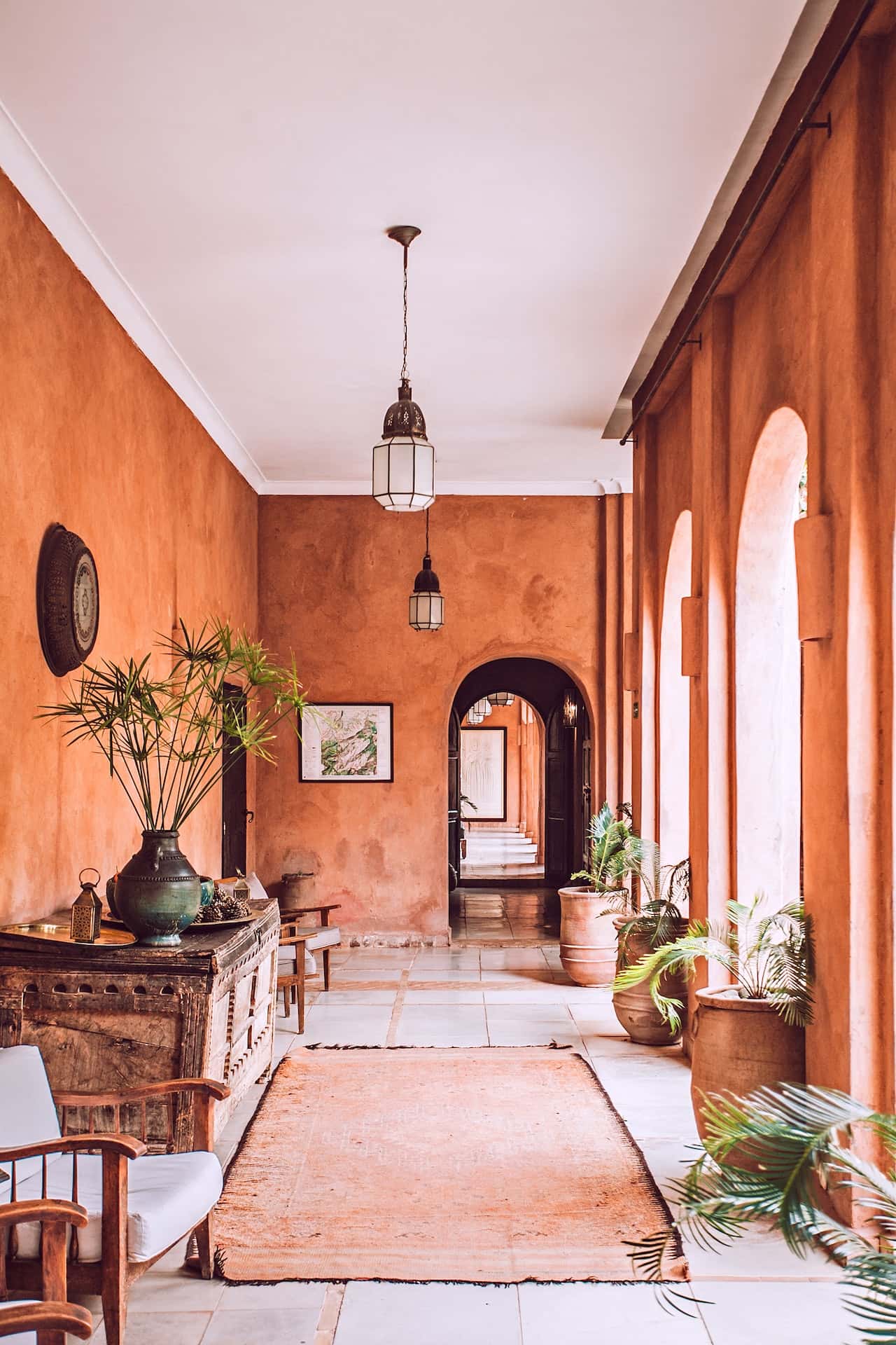 Elegant pop design for porch enhances this arched corridor with a warm earthy vibe