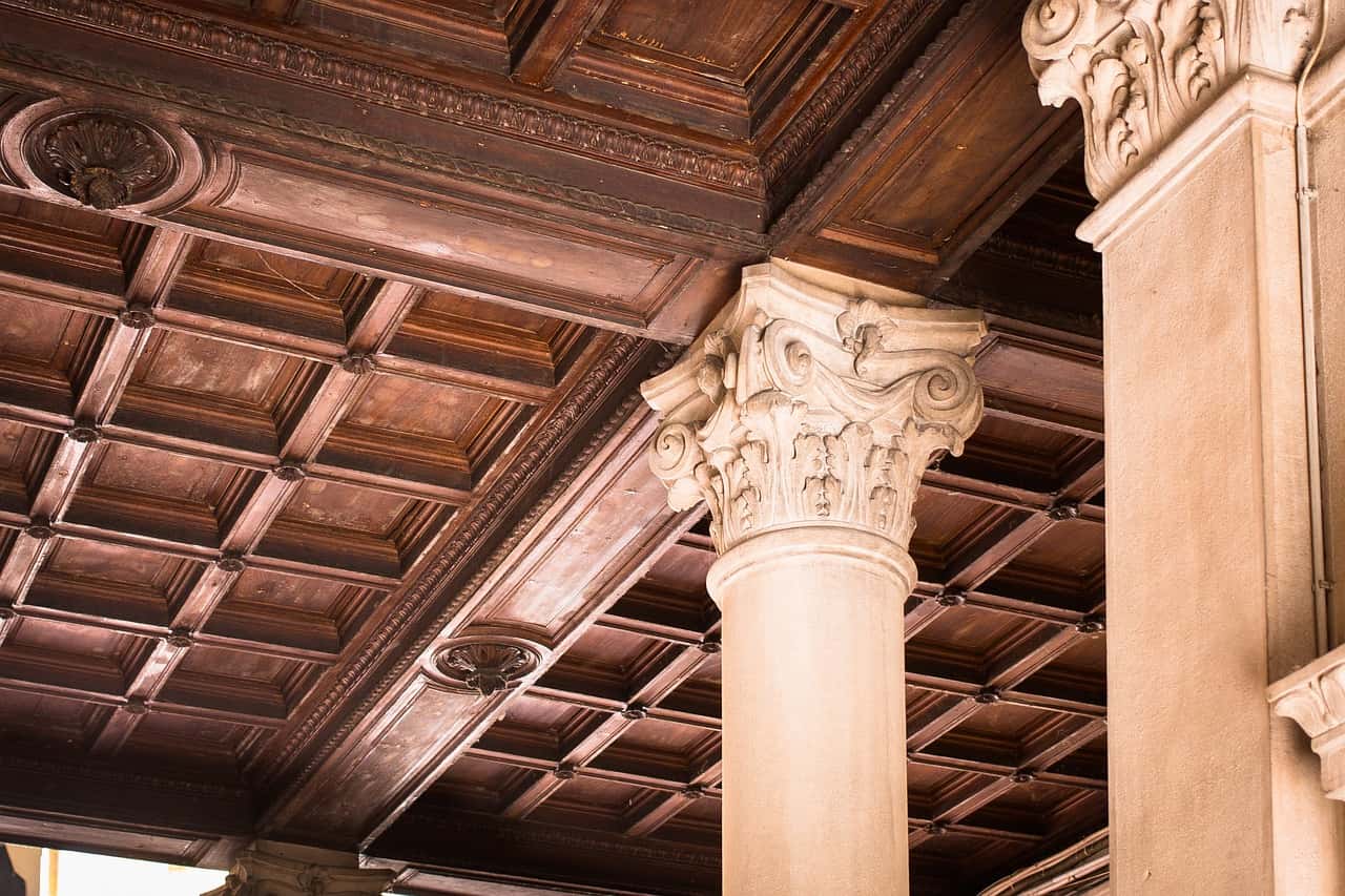 Elegant pop design for porch with vintage wooden ceiling and carved stone pillars