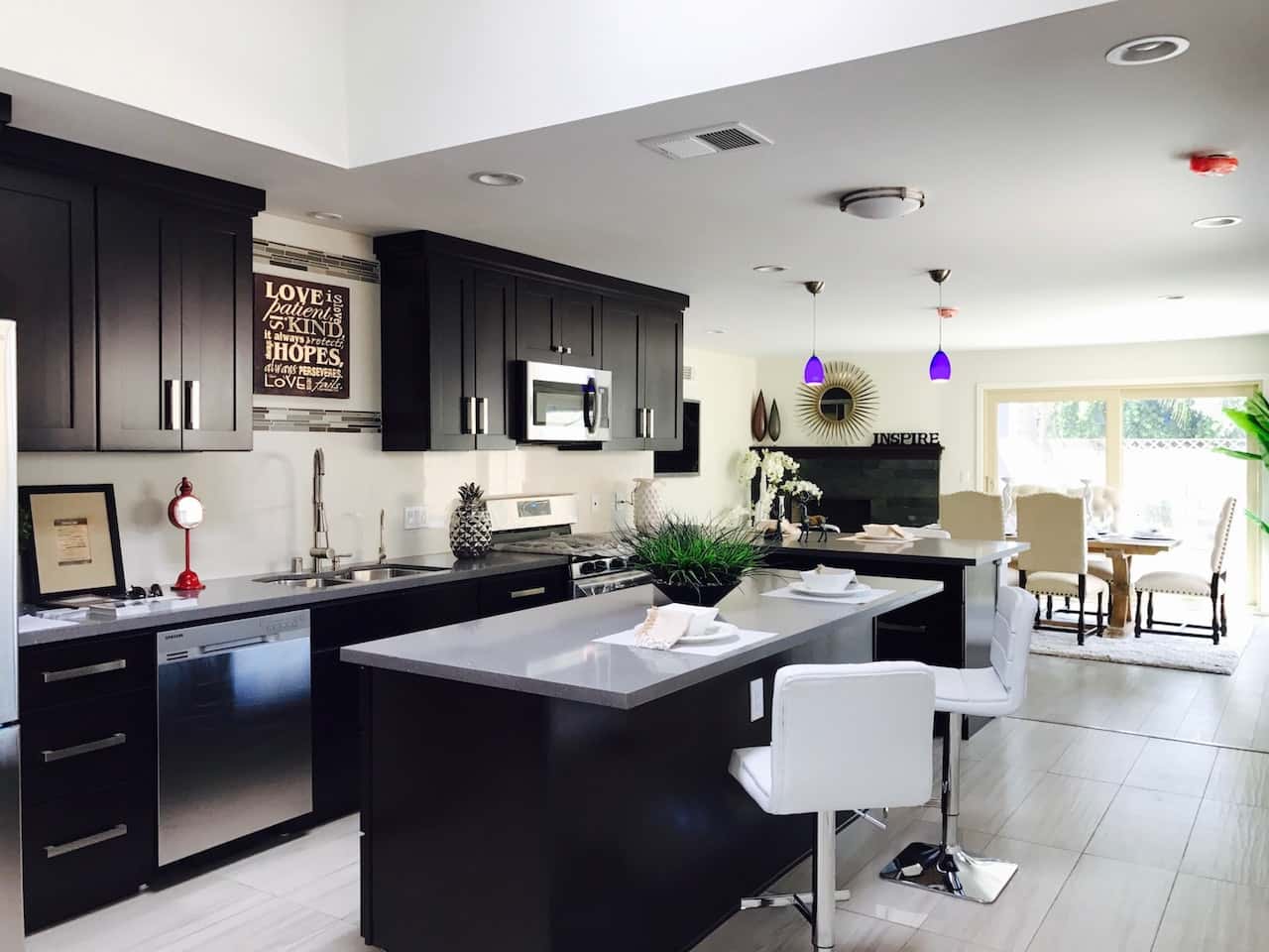 Sleek kitchen entrance design featuring dark cabinetry and open layout